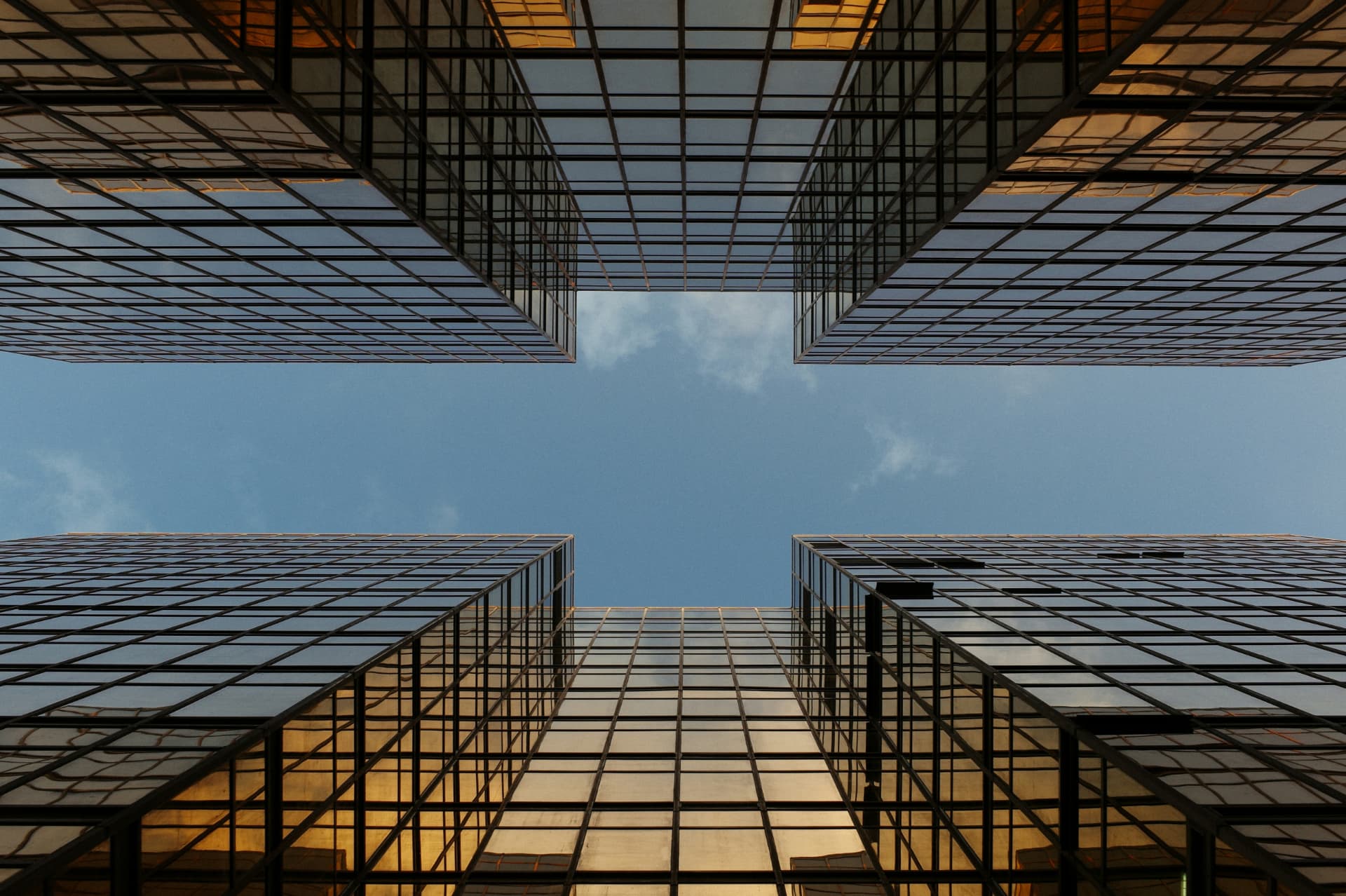 Glass office towers viewed from below against the sky