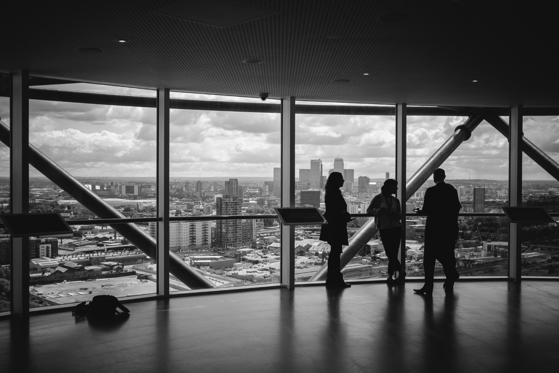 Professionals talking beside floor to ceiling windows overlooking a city skyline